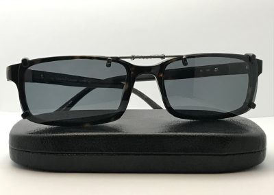 Spring bridge clip on sunglasses with gray lenses over Calvin Klein CK7739, on top of a case